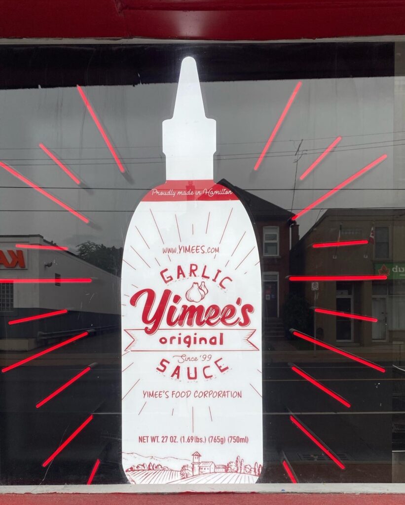 A window advertisement for Yimee's garlic sauce